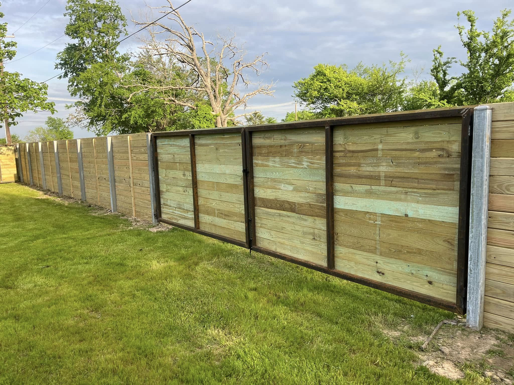 Wooden privacy fence installation in residential backyard for improved security and property value – Hood Lawn Care and Services
