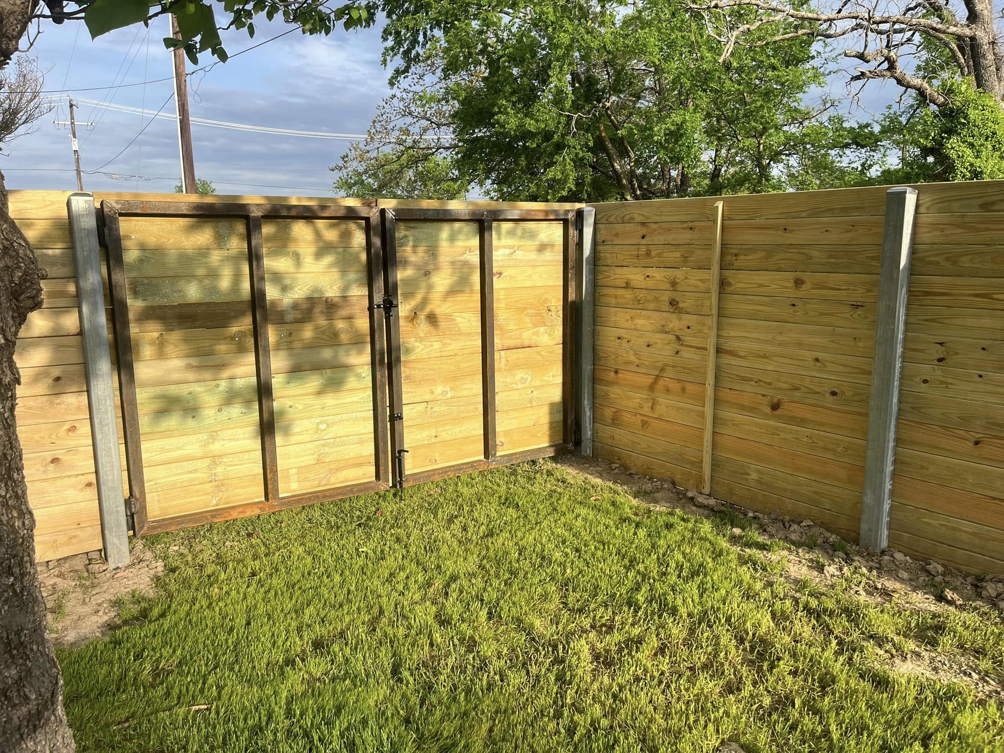 Wooden privacy fence installation in residential backyard for improved security and property value – Hood Lawn Care and Services