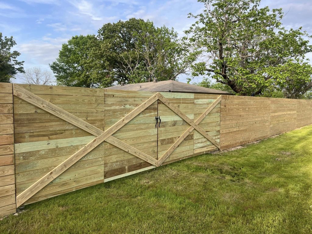 Wooden privacy fence installation in residential backyard for improved security and property value – Hood Lawn Care and Services