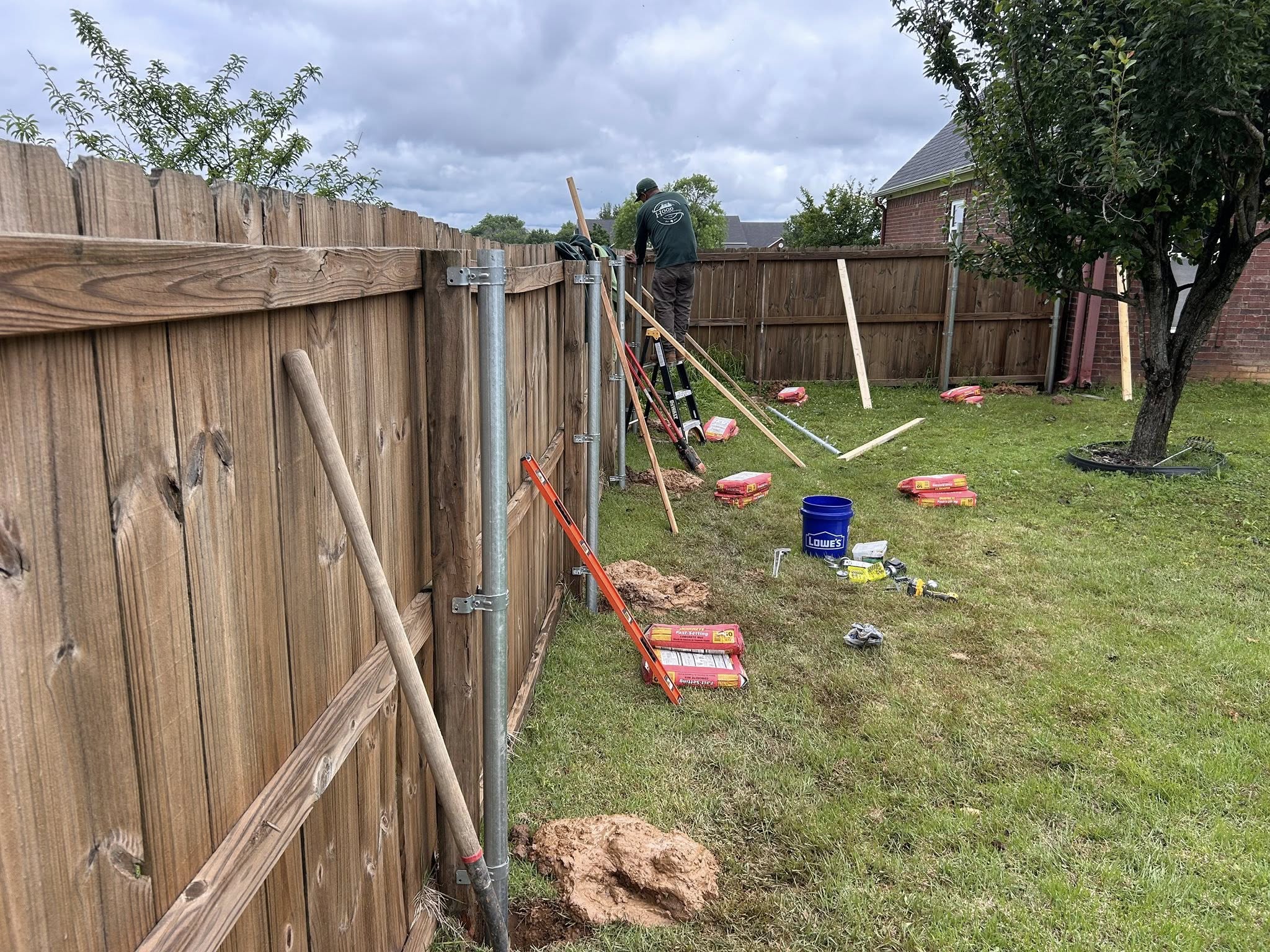 Wooden privacy fence installation in residential backyard for improved security and property value – Hood Lawn Care and Services
