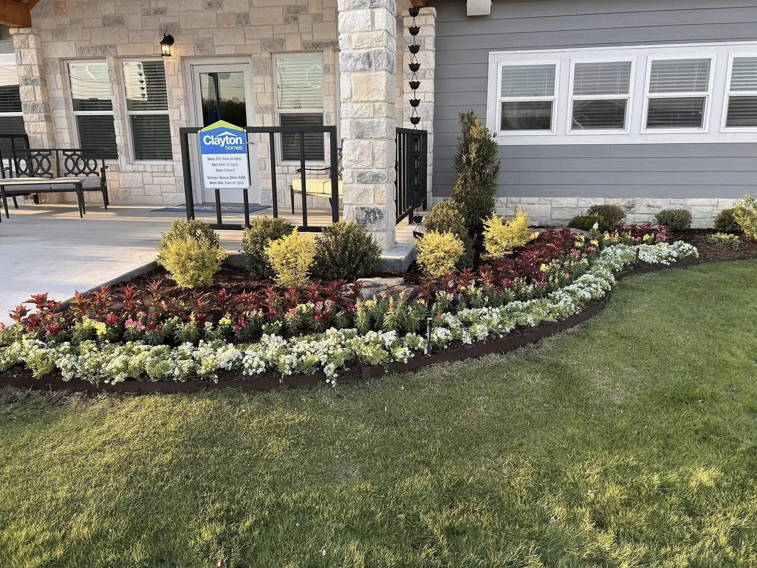 Professional flower bed installation with colorful landscaping in front of Clayton Homes Texas